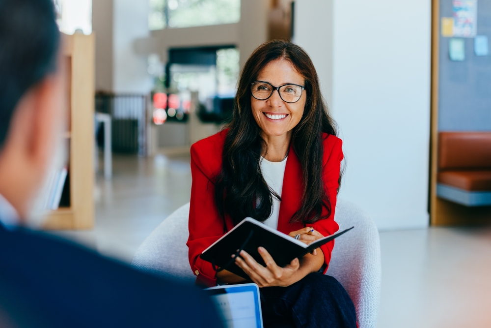 Professional Woman With Glasses And A Red Blazer Sitting